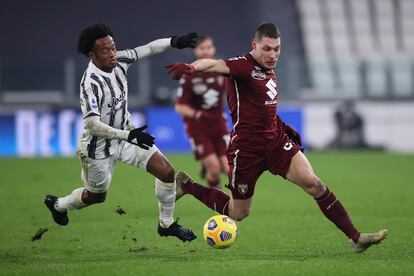 El delantero del Torino Andrea Belotti se lleva el balón ante el juventino Cuadrado.