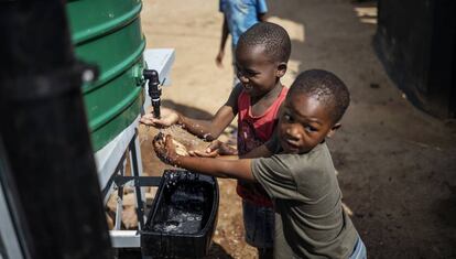 Unos niños se lavan las manos en un asentamiento informal de Sudáfrica.