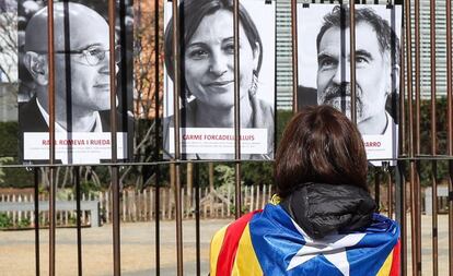 Una simpatitzant independentista mira les fotografies de polítics catalans presos exposades a la plaça de Schuman (Brussel·les).