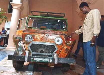 El artista Dominique Zinkpe, de Benin, junto a su obra <i>Taxi Bush, </i><b>en la Bienal d</b><b>e La Habana</b>.