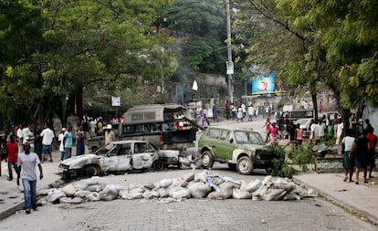 Un grupo de haitianos camina entre una de las barricadas instaladas en la capital tras las propuestas por los resultados electorales.