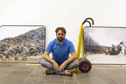 El fotógrafo Adrián Ruiz de Hierro posa ante una de las obras de la exposición 'En el arcén de camino al norte'.