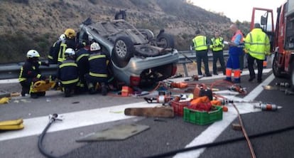 Firefighters extract bodies from a car following an accident in Granada.