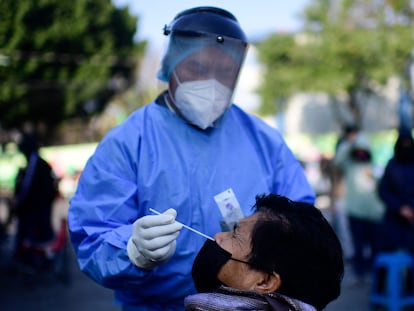 Un trabajador de la salud toma una muestra a una persona con síntomas de covid-19 en Iztapalapa, Ciudad de México, este lunes.