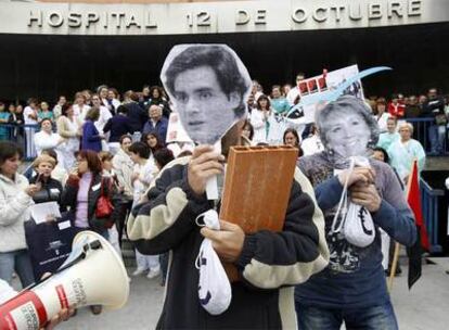 Dos liberados sindicales, con las caretas de Juan José Güemes y Esperanza Aguirre, en el hospital 12 de Octubre.