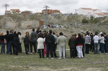 Los vecinos de la zona donde ha sido localizado el cadáver de la niña de 13 años, esta tarde tras el cordón policial.