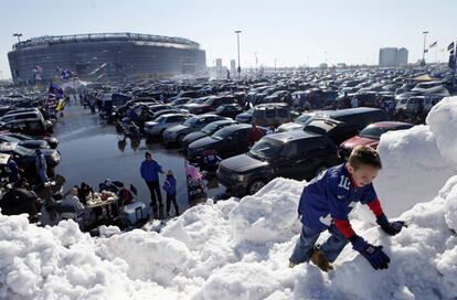 Un niño escala una montaña de nieve en las afueras del estadio Metlife en Nueva Jersey.