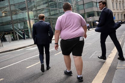 Unos hombres cruzan la calle en la City de Londres.