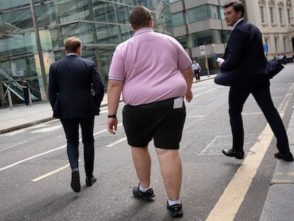 Unos hombres cruzan la calle en la City de Londres.