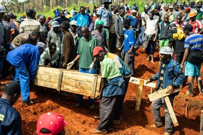 Varias personas trasladan ataúdes mientras en un entierro múltiples en Chimanimani Heroes Acre (Zimbabue) tras el paso del ciclón Idai, el 18 de marzo de 2019.