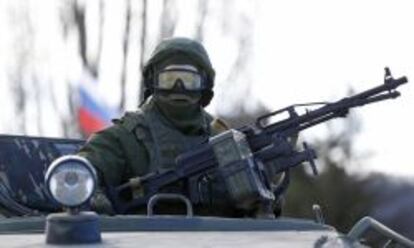 Un soldado sin identificación, probablemente ruso, monta guardia frente a una unidad militar ucraniana.