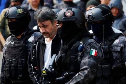 Damaso López escoltado en Ciudad de México por policías después de ser detenido.