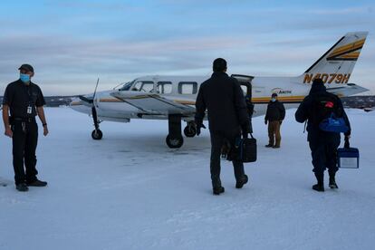 Un equipo de trabajadores de la salud se prepara para abordar un vuelo en Fairbanks, Alaska para distribuir la vacuna en el Estado.