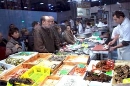 Varias personas compran en un mercado de Bilbao para preparar la cena de Nochebuena y la comida de Navidad. EFE/Archivo