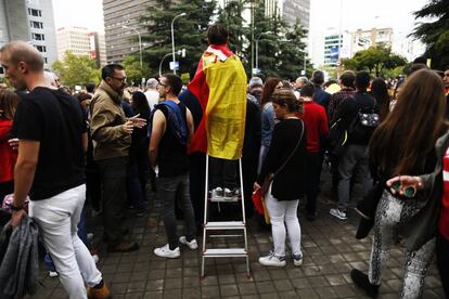 Miles de personas han acudido este viernes a la parada militar que se celebra con motivo de la Fiesta Nacional. En la imagen, un joven subido a una escalera momentos antes del desfile.