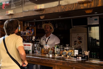 Un camarero atiende a un cliente en una cafetería sin luz en Cannes.