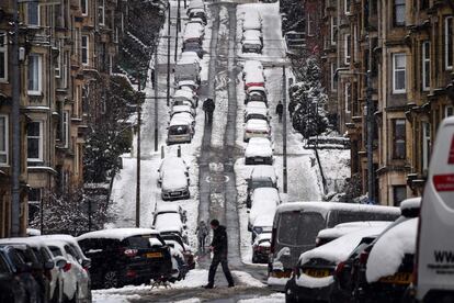 Un hombre cruza una calle nevada de Glasgow (Reino Unido).