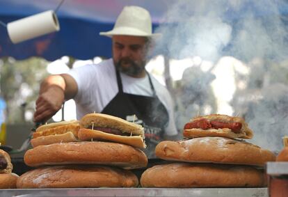 Un cocinero prepara bocadillos de chorizo en la feria de San Isidro.