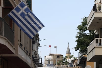 Una bandera griega ondea frente a las banderas turca y turcochipriota cerca de la zona controlada por la ONU en Nicosia.