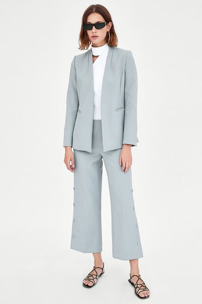 En Zara encontramos este dos piezas en azul empolvado. La chaqueta cuesta 39,95 y el pantalón, de tipo culotte con detalle de botones, 29,95 euros.