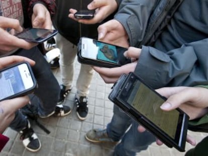 Varios jóvenes conectados a las redes sociales a través de sus teléfonos móviles.