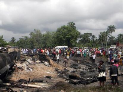 Los vecinos de la zona observan el lugar de la explosión que dejó más de un centenar de muertos el jueves.