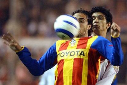 Emiliano Moretti del Valencia controla el balón con el pecho ante Renato Dirnei Florencio, del Sevilla.