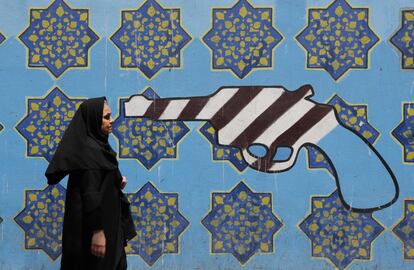Una mujer iraní camina junto a un mural en la pared de la antigua embajada de Estados Unidos en la capital iraní, Teherán.