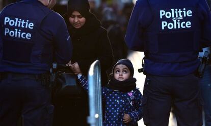 Policías registran a una mujer que se dirige a un acto en recuerdo de las víctimas en Molenbeek (Bruselas).