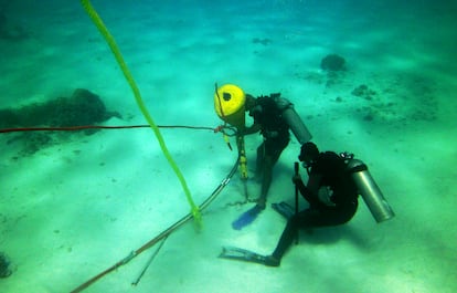 Dos buceadores instalan un sistema de amarres en la arena del mar Rojo para evitar que los barcos lancen anclas y destruyan los corales, el 3 de noviembre en Hurghada.