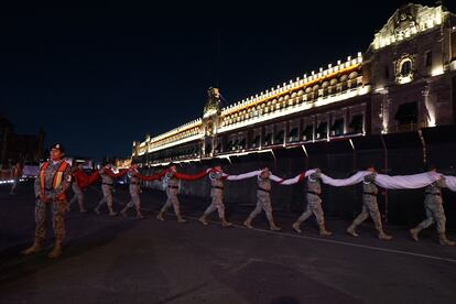 Militares retiran la bandera de la plancha del Zócalo en anticipación a la marcha, el lunes por la noche.