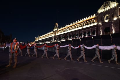 Militares retiran la bandera de la plancha del Zócalo en anticipación a la marcha, el lunes por la noche.