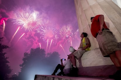 Un grupo de personas contemplan los fuegos artificiales junto al monumento a Lincoln, en Washington (EE UU).