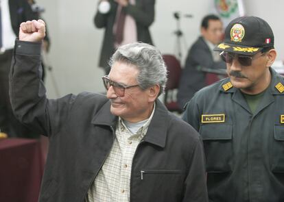 El líder del grupo Sendero Luminoso, Abimael Guzmán, levanta el puño durante el primer día del juicio contra él y otros militantes de la agrupación, en la prisión de alta seguridad de Callao (Perú), en 2004.