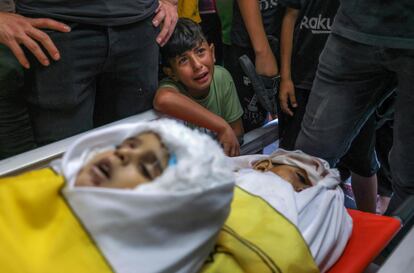 Un niño llora junto a los cuerpos de cuatro adolescentes palestinos, durante el funeral en Jabalia, en el norte de la Franja de Gaza, este lunes. De los fallecidos reconocidos este lunes por Israel, solo 19 serían miembros de Yihad Islámica.