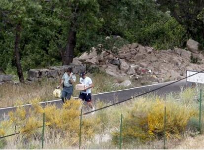Guardias civiles trasladan el material encontrado ayer en un <i>zulo</i> cerca de Madrid.