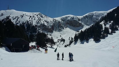 Un grup d'esquiadors gaudeix d'un assolellat dia d'abril a la neu.