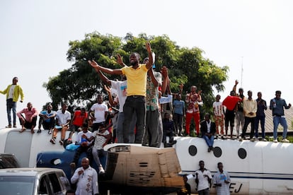 Varias personas subidas a un avión viejo mientras el Papa Francisco celebra una misa en el aeropuerto de Ndolo durante su viaje apostólico, en Kinshasa, este miércoles.