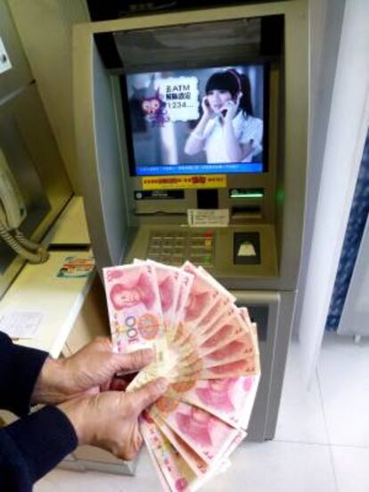 Un hombre muestra billetes en yuanes sacados de un cajero. EFE/Archivo