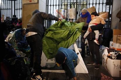 A family of refugees pitch their tent outside of Samur Social to get out of the rain.