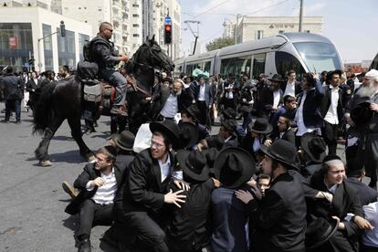 Un policía israelí intenta dispersar una manifestación judía ultraortodoxa contra el Desfile Gay anual en Jerusalén.