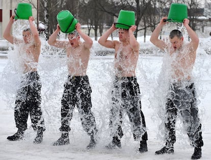 Soldados bielorrusos participan en una especie de bautizo en una ceremonia de juramentación en Minsk, donde hoy las temperaturas han llegado a estar 8 grados bajo cero