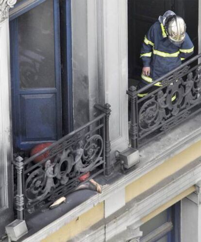 Un bombero, junto a una de las víctimas mortales del incendio en un banco de Atenas.