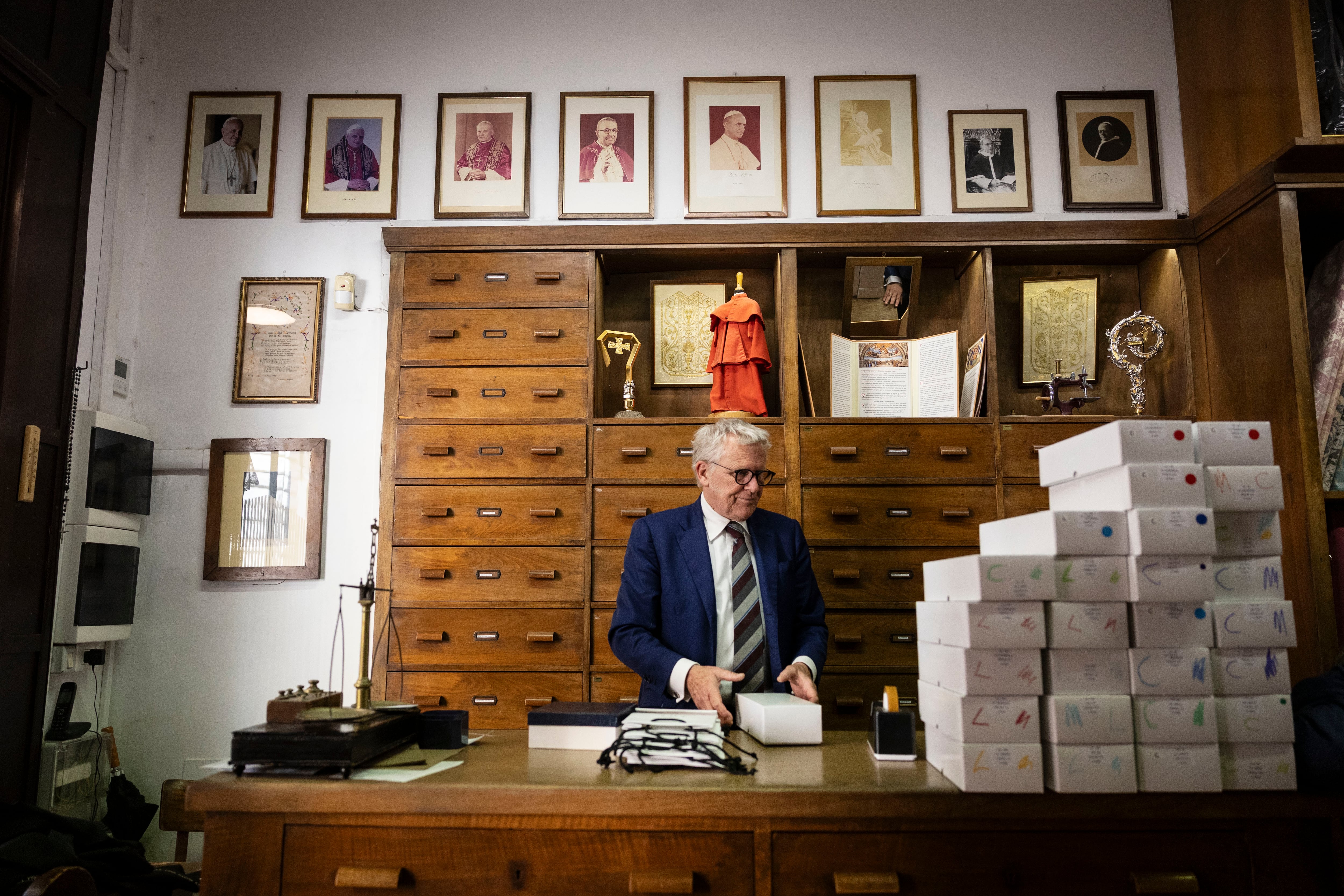 El mostrador de  la sastrería Gammarelli, famosa en el centro de Roma, con las fotos de todos los Papas a los que fabricaron vestidos. 