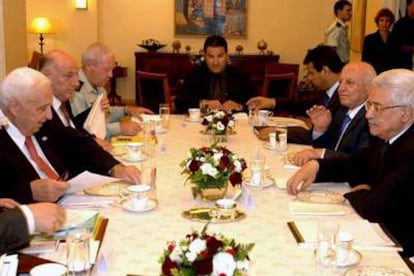 El presidente palestino, Mahmud Abbas (a la derecha), y el primer ministro israelí, Ariel Sharon, junto a sus asesores durante la reunión de ayer.