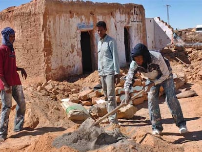 Saharauis trabajan en la reconstrucción de sus casas, arrasadas por las lluvias, en los campos de Tinduf.