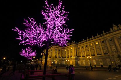 Los arboles iluminados con luces moradas le dan luz a la plaza de Oriente.