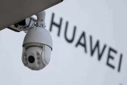 C&aacute;mara de vigilancia junto a un letrero de Huawei en Pek&iacute;n.
