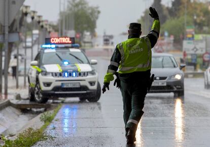 Un agente de la Guardia Civil da el alto a un conductor durante un control establecido este sábado a la salida de Sevilla hacia la provincia de Huelva.