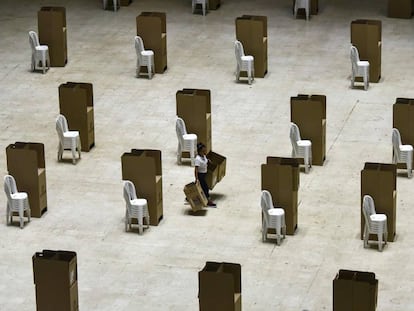 Una mujer transporta el viernes cabinas de votación en un colegio electoral de Cali.